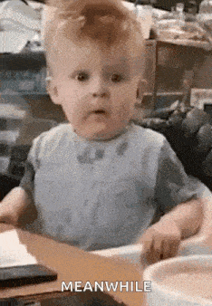 a baby is sitting in a high chair at a table with a bowl of food .