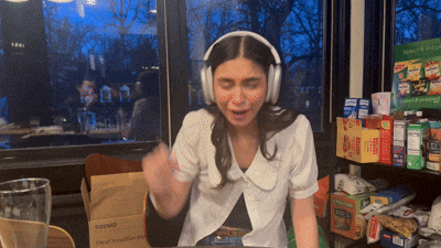 a woman wearing headphones sits at a table in front of a box that says soumd