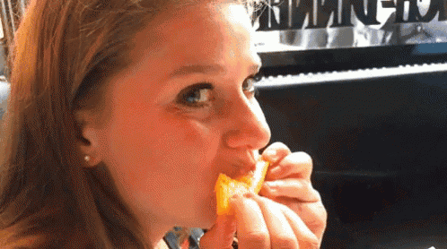 a woman is eating a piece of food in front of a piano with the word piano on the keyboard