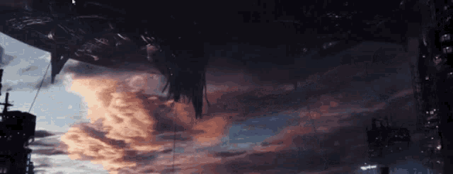 a large space ship is flying in the sky over a city at sunset .