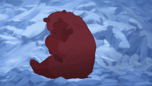a red bear is sitting in the snow hugging its cub