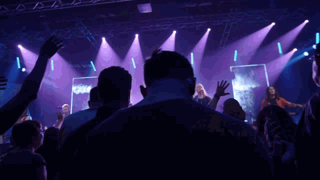 a group of people are watching a band on stage
