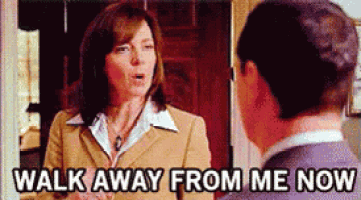 a woman in a suit is talking to a man in a suit and says walk away from me now .