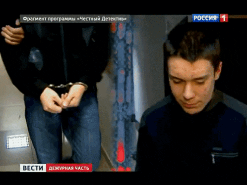 a man in handcuffs is being shown on a tv screen