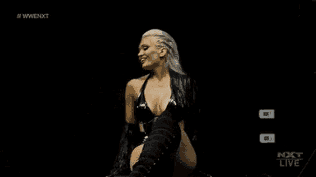 a female wrestler is sitting on a chair in a dark room .