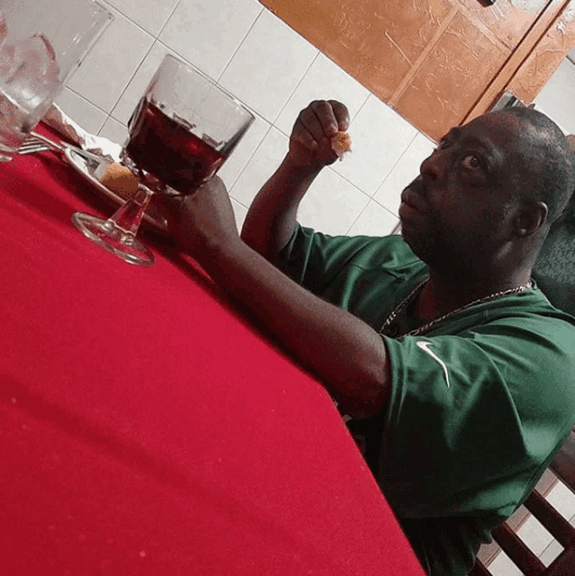 a man sitting at a table with a glass of wine