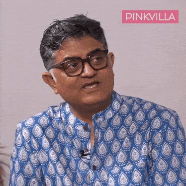 a man wearing glasses and a blue shirt with pinkvilla on the bottom right