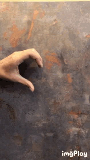 a person 's hand is making a heart shape with their fingers on a dark background