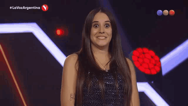 a woman is smiling in front of a sign that says lavozargentina