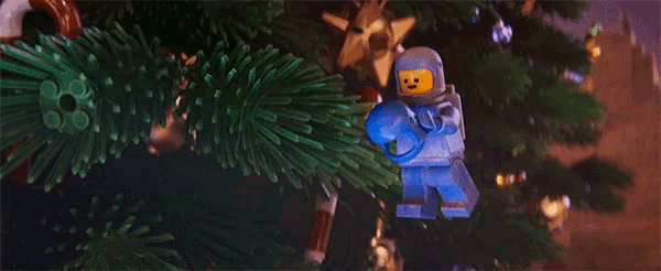 a blue lego man is hanging from a christmas tree