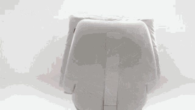 a man in a white shirt is sitting in an airplane seat and smiling .