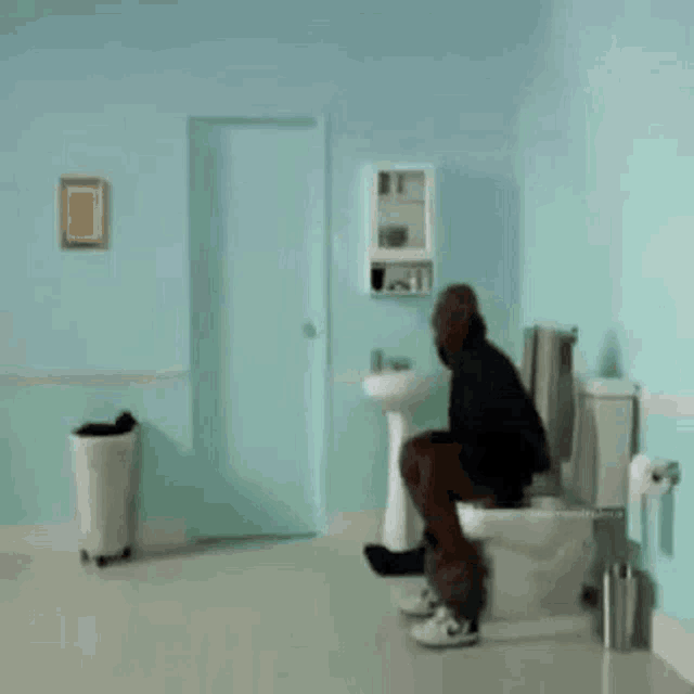 a man is sitting on a toilet in a bathroom with the words caga above him