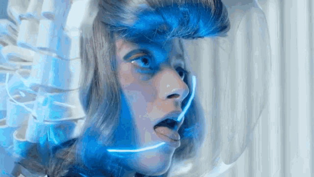a close up of a woman 's face with blue lights coming out of it
