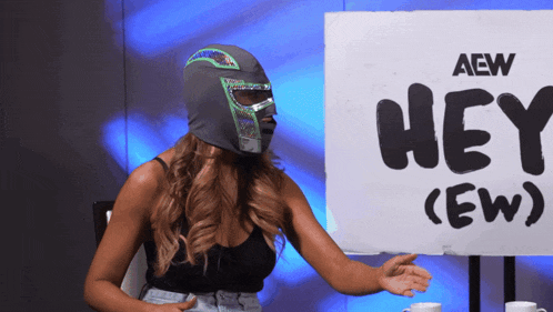 a woman in a mask is standing in front of a sign that says hey ( ew )