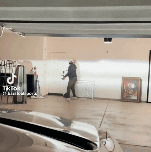 a man is standing in a garage with a tiktok sticker