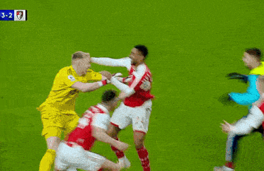 a group of soccer players are fighting on the field .