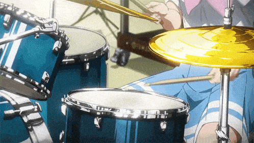 a person playing a drum set with a cymbal in the foreground