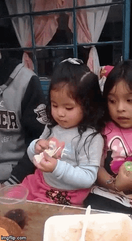 two little girls are sitting at a table with a man wearing a sweatshirt that says dept on it