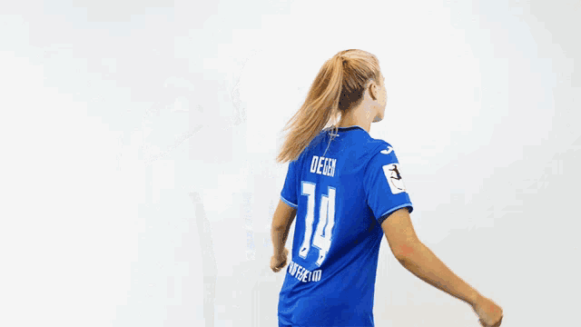a girl wearing a blue jersey with the number 14 on it