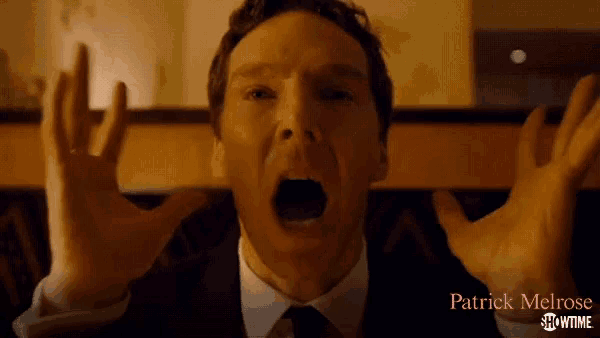 a man in a suit and tie is making a funny face with his hands in the air .