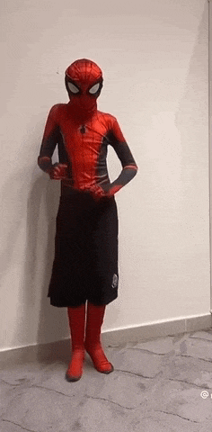 a person in a spider-man costume is standing in front of a wall .