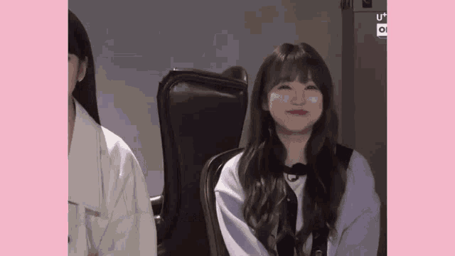 a girl is sitting in a chair with her eyes closed and smiling .