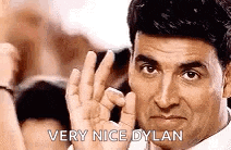 a man is giving a thumbs up sign with his fingers and says `` very nice dylan '' .