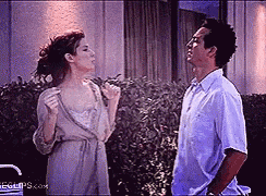 a man and a woman are standing next to each other looking at each other .