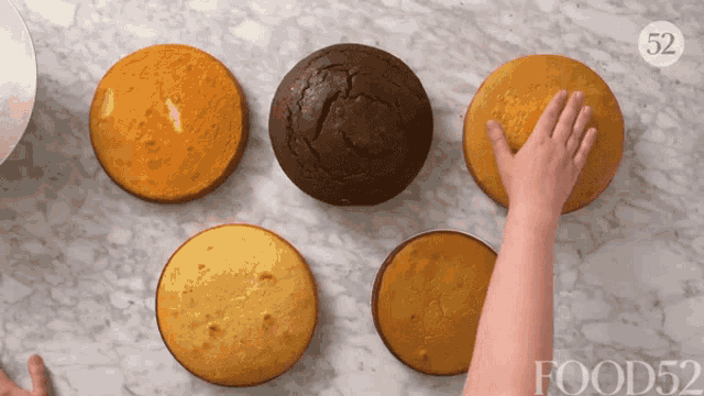 a person reaches for a cake with the number 52 on the bottom right