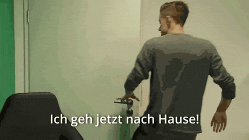 a man is standing in front of a door with the words ich geh jetzt nach hause