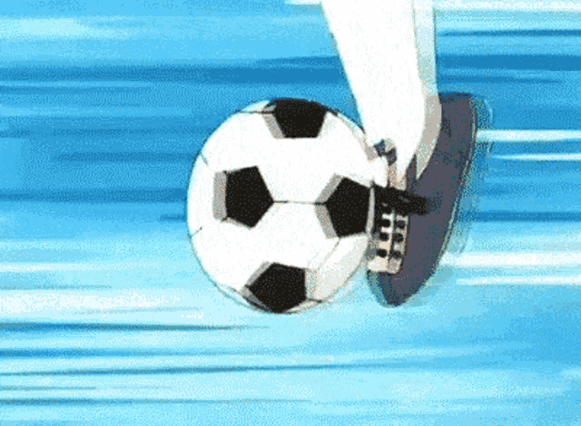 a soccer player is kicking a soccer ball in the air .