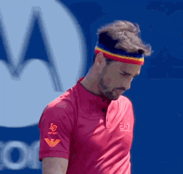 a man wearing a headband and a red shirt with ea7 on the sleeve