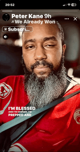 a man with a beard and a red shirt is on a phone screen that says peter kane 9h