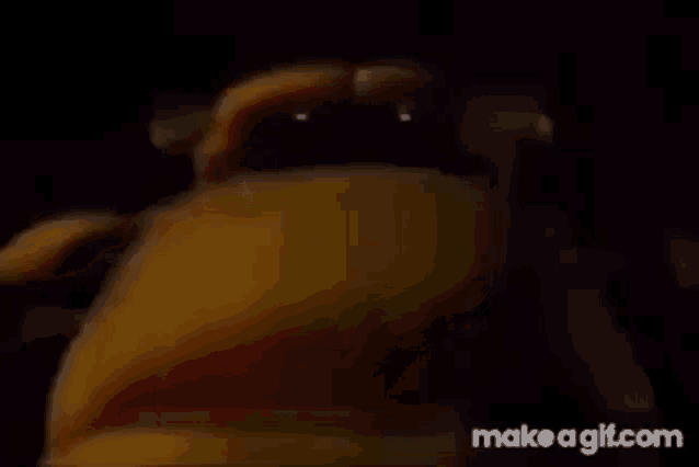 a close up of a yellow object in a dark room with a black background .