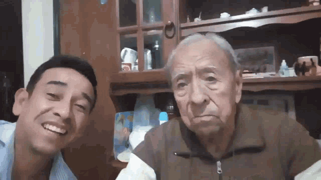 an older man and a younger man pose for a picture