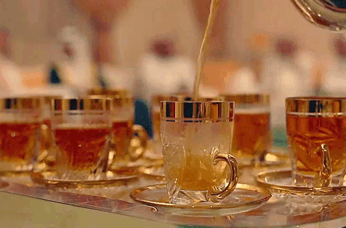 a cup of tea is being poured into a saucer on a table