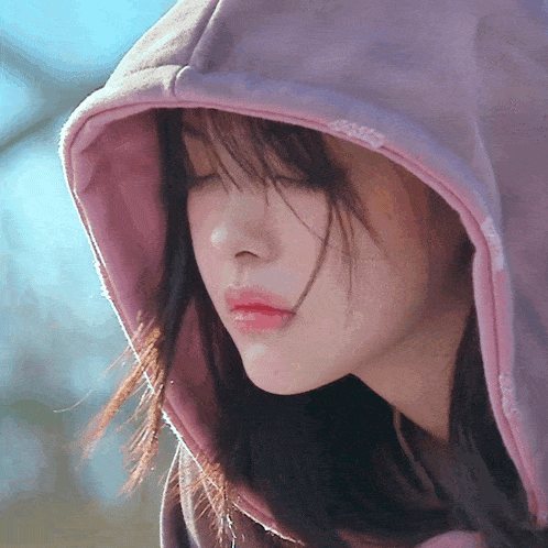 a close up of a woman wearing a hoodie