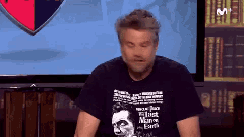 a man wearing a black t-shirt that says " the last man on earth "