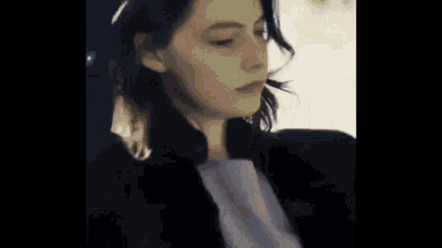 a close up of a woman 's face with her eyes closed .