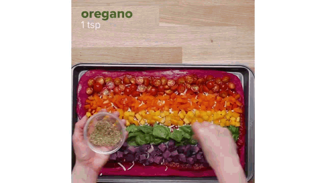 a person is adding oregano to a rainbow colored pizza crust .