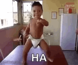 a baby in a diaper is standing on a table with the word ha written on the bottom