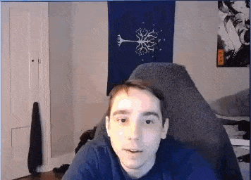 a young man is sitting in a chair in a room with a flag on the wall .