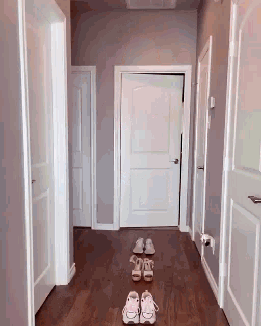 a hallway with a pair of shoes on the floor in front of a door