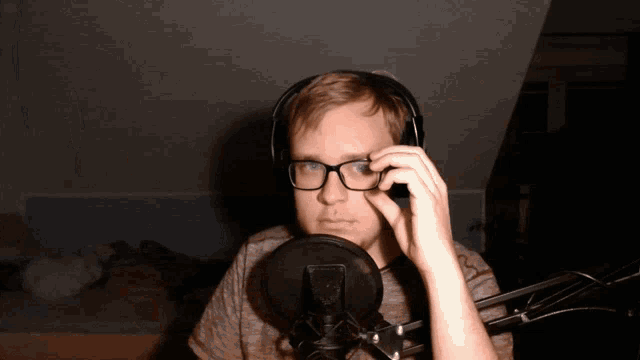 a man wearing glasses and headphones looks at the camera