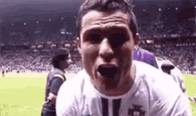 a close up of a soccer player making a funny face on a field .