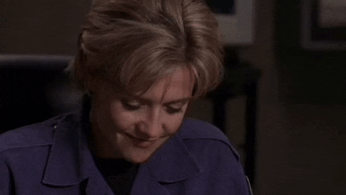 a woman in a purple uniform is smiling at the camera .