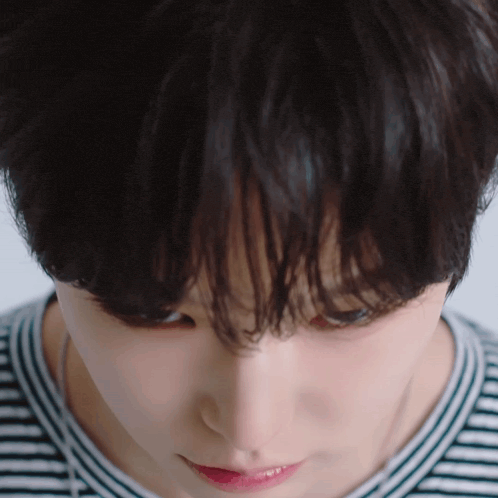 a close up of a woman 's face with a striped shirt
