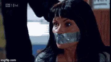 a woman with duct tape on her mouth is sitting in front of a man .
