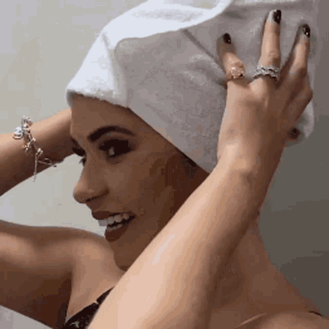a woman with a towel wrapped around her head has a ring on her finger