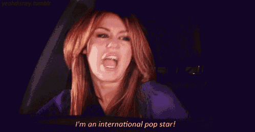 a woman with red hair is making a funny face and saying `` i 'm an international pop star ''